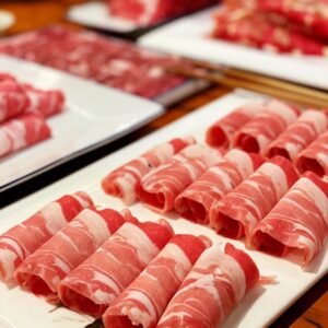 sliced raw meat on white ceramic plate